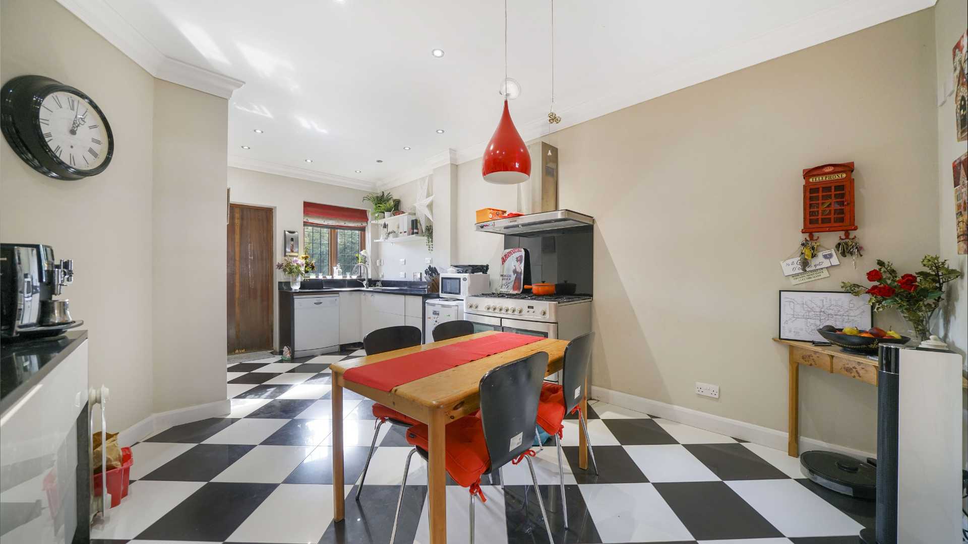 Dining space with piano and doorway opening into garden room with large windows
