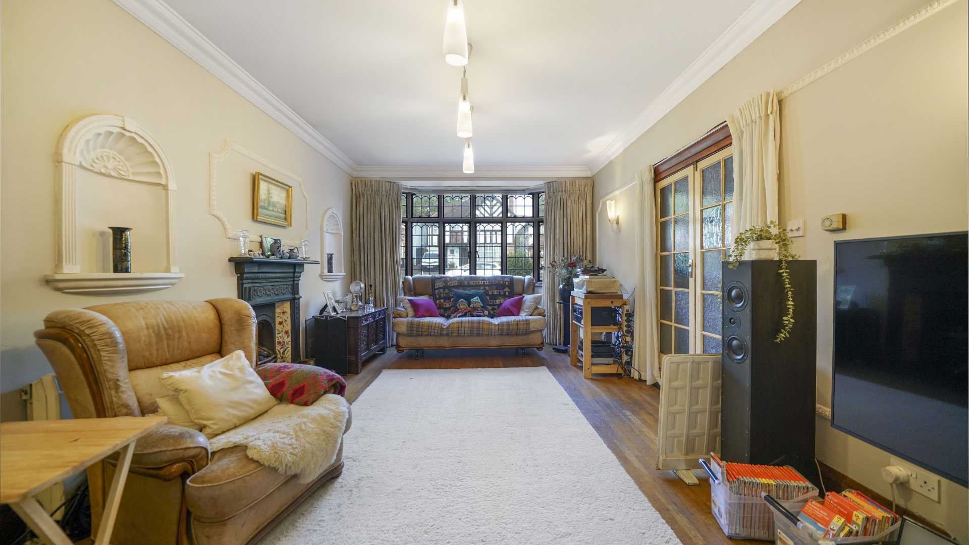 Garden room with exposed brick walls, large windows and view over rear lawn
